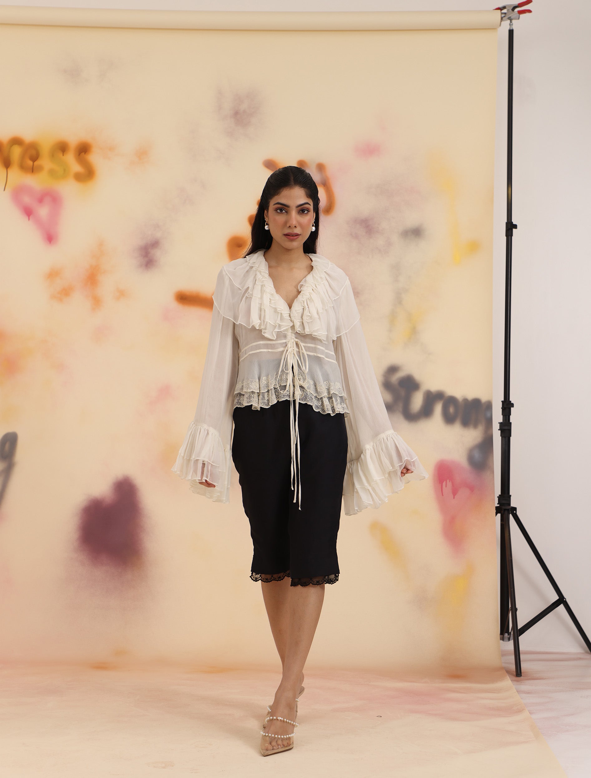 Full-length view of black Laced Capri Pants styled with sheer blouse