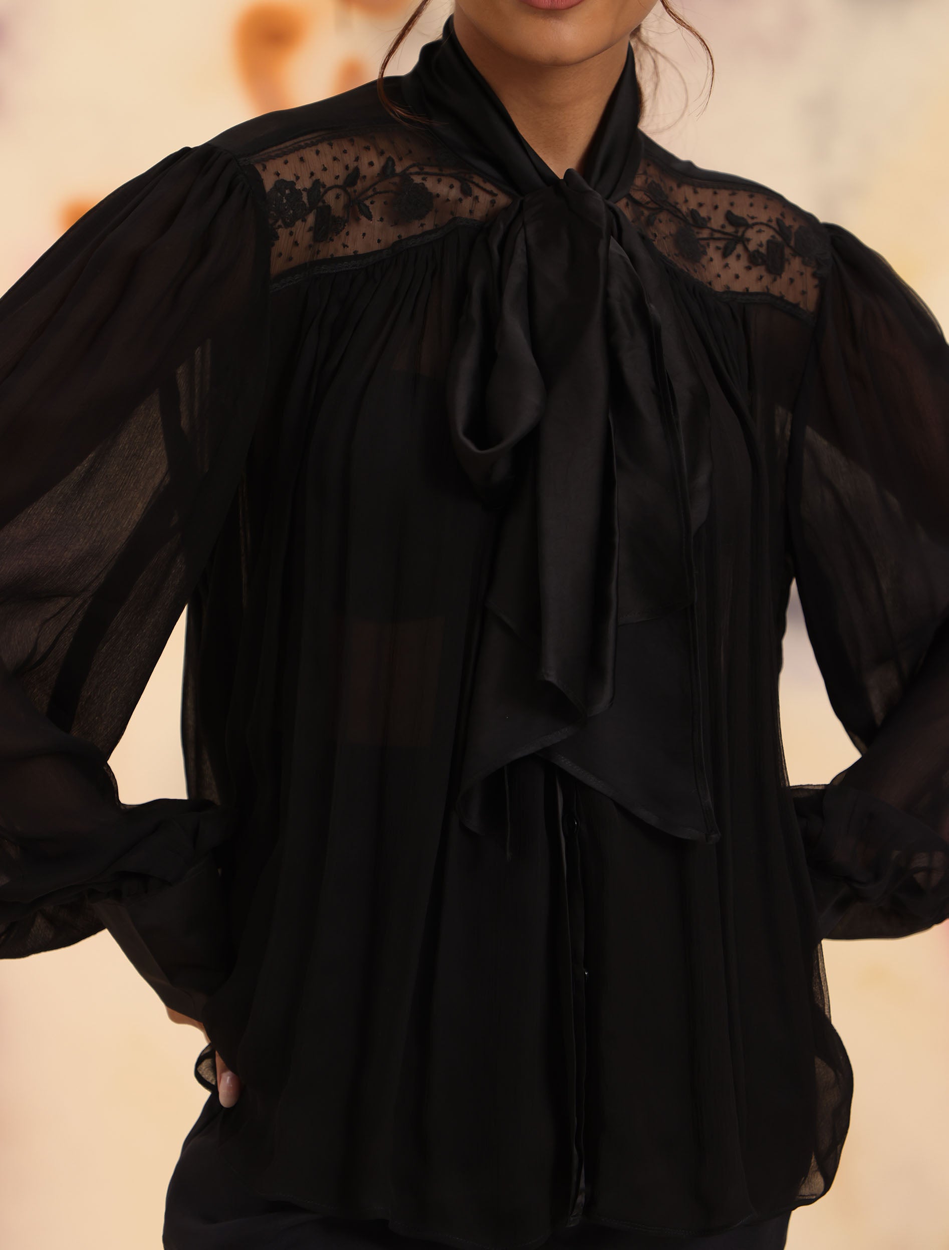 Close-up of black Sheer Tie Shirt showing floral lace yoke and lavallière tie neck detail, Nishtha Bansal