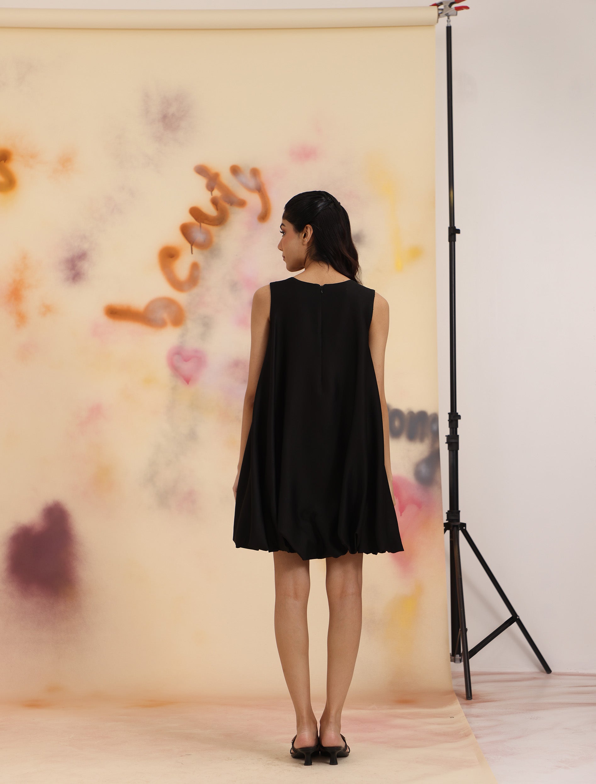 Back view of black Cloud Hem Embellished Dress with relaxed drape